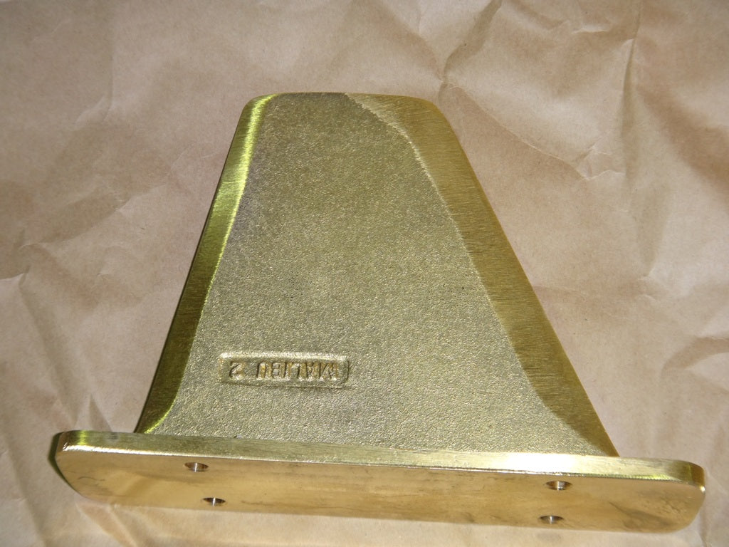 Gold-colored metal fin component labeled "Response TXi: 12" on crumpled paper background.