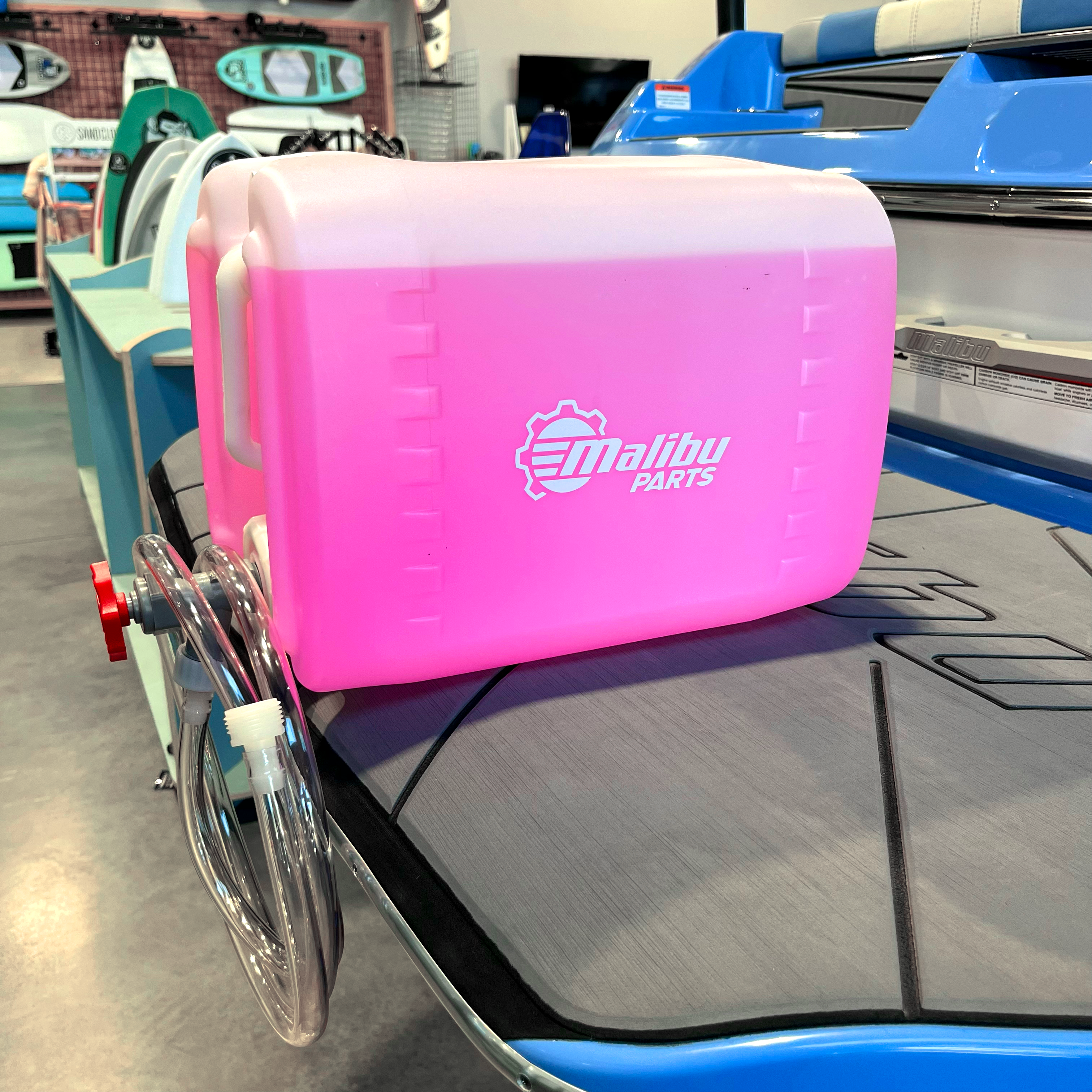 Pink 5-gallon winterize kit with hoses and fittings, designed for boat engine protection during cold weather.