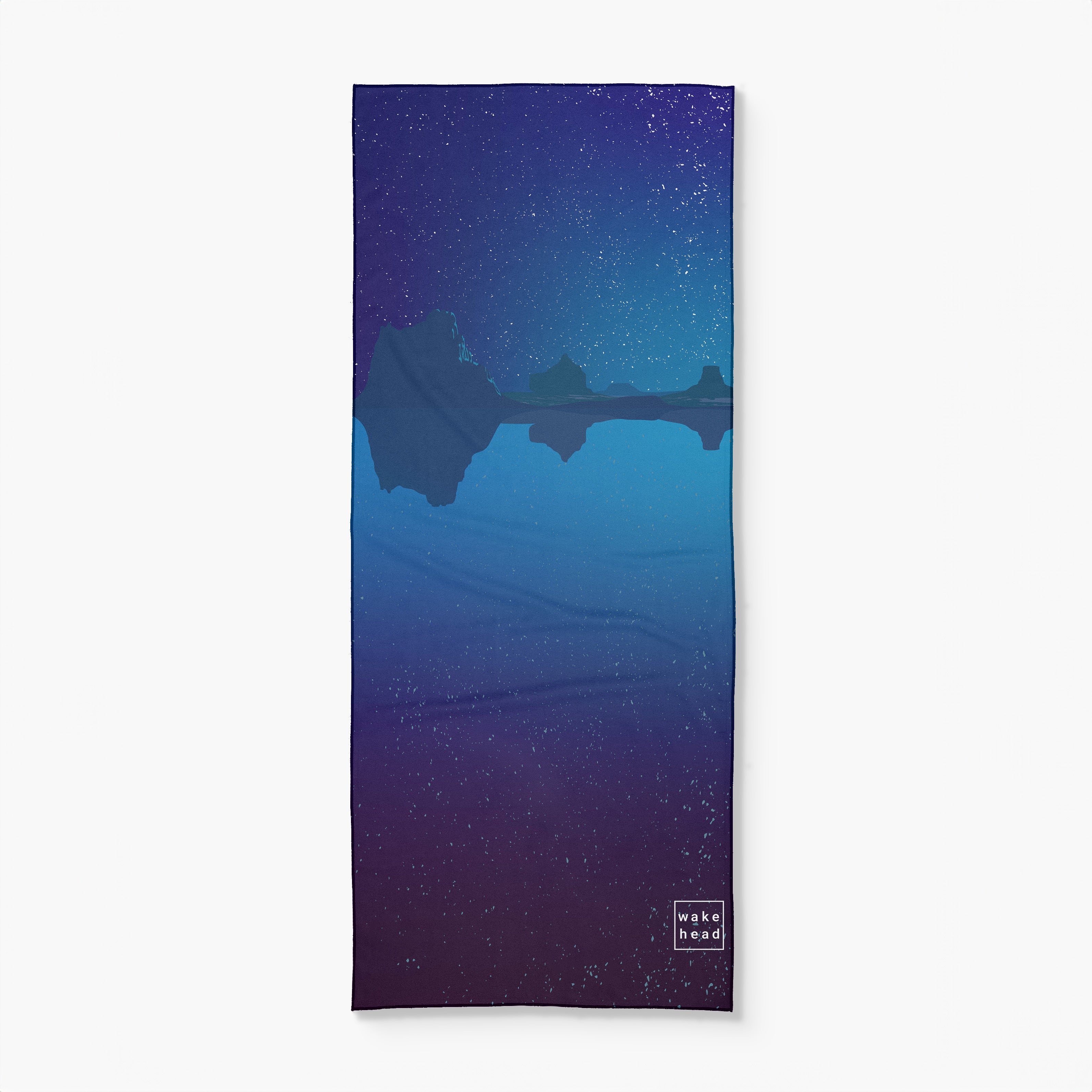 A yoga mat featuring a serene night sky with stars over mountain silhouettes reflected in water, labeled "Wake Head - Canyon Dreams.