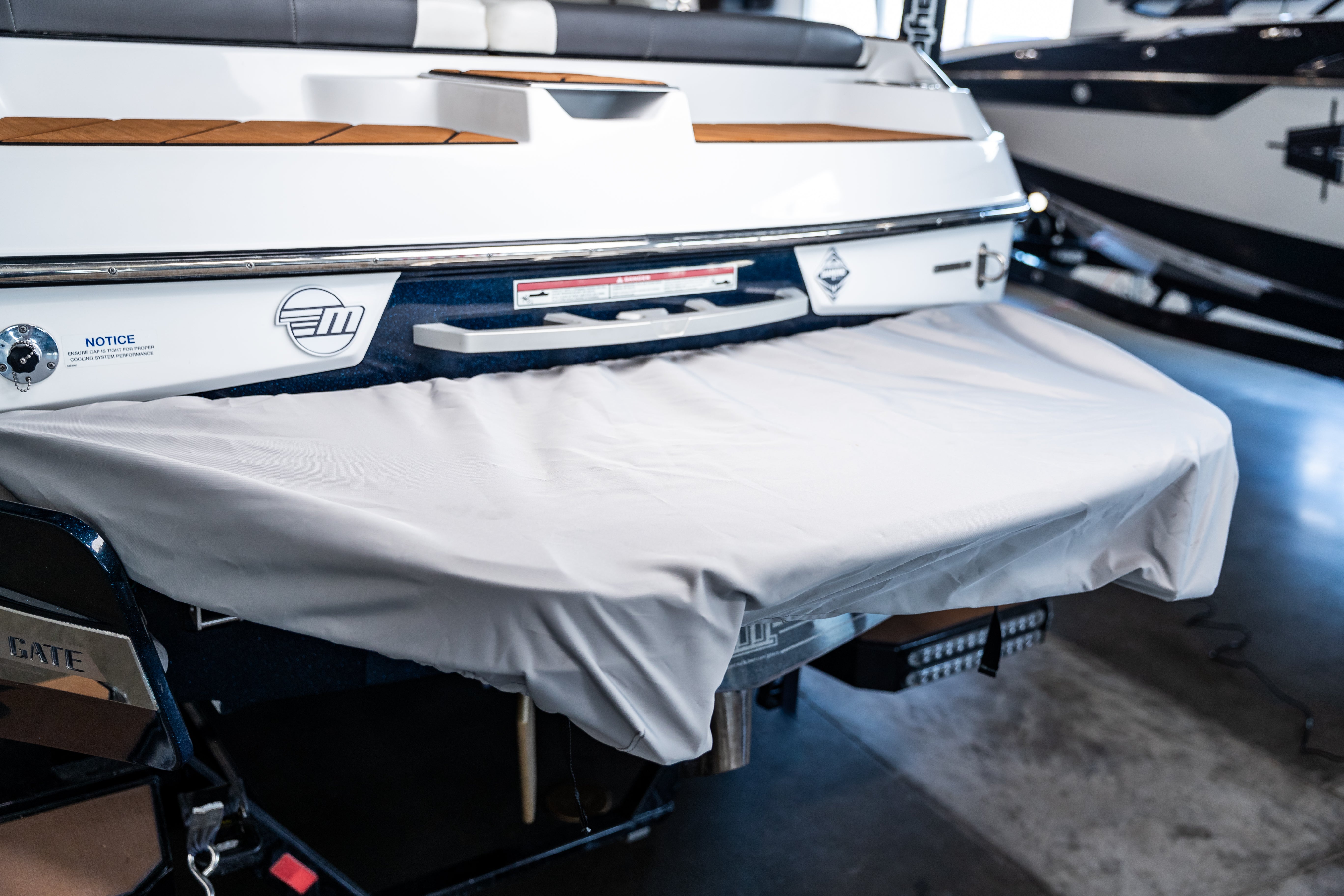 Swim platform cover on a Malibu boat, protecting the platform from dirt and damage, with a white fabric cover.