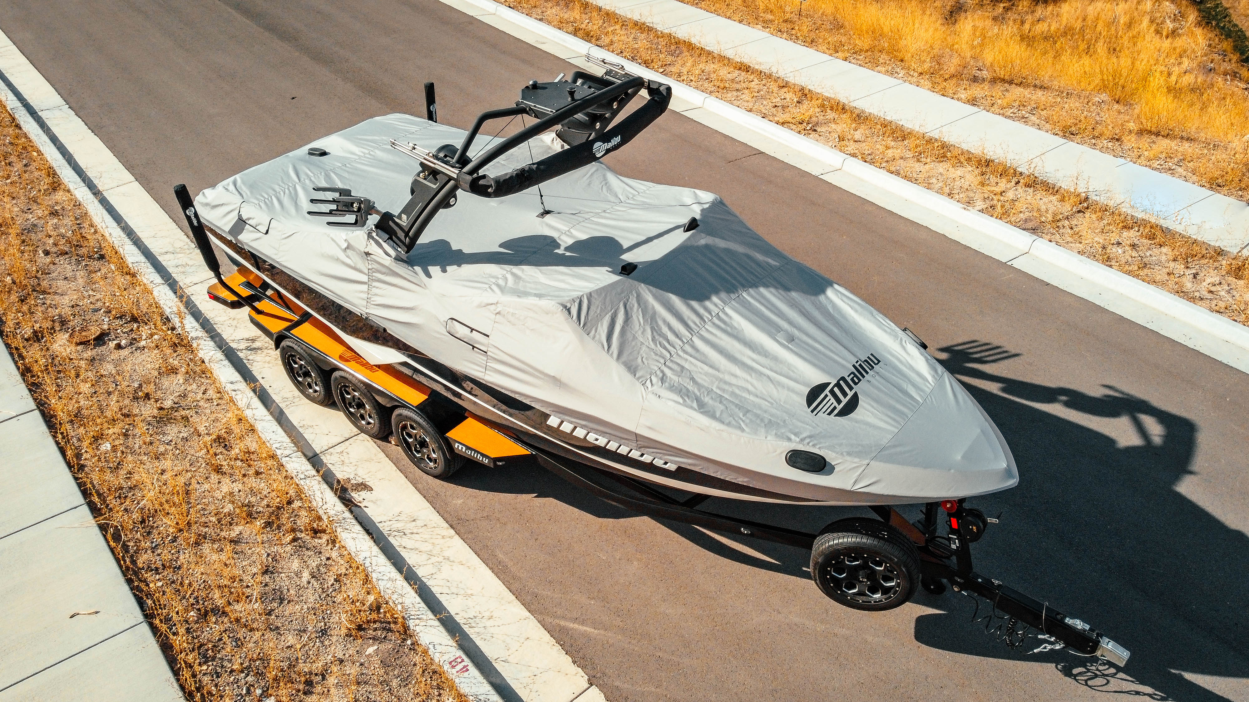 Malibu 23 LSV boat cover with bow cleats, mounted on a trailer, featuring a G3 tower and protective cover.